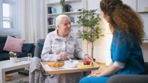 Older adults practice gentle balance exercises in a bright assisted living activity room.