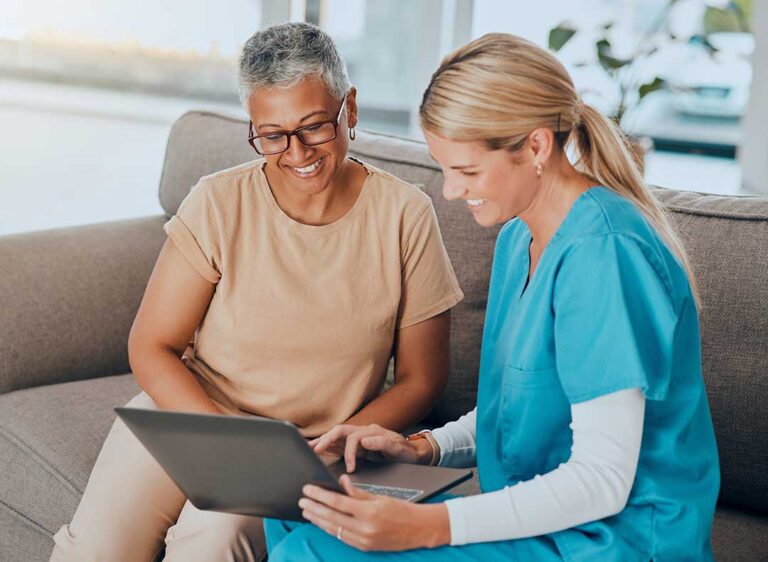 Family members review a care plan with an older adult at a table in an assisted living common room.